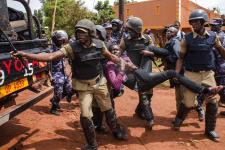 Police officers arrest a supporter of Ugandan musician turned politician Robert Kyagulanyi, commonly known as Bobi Wine, before his arrest on his way to a press conference held to announce the cancelation of his show at Busabala, Uganda, on April 22, 2019