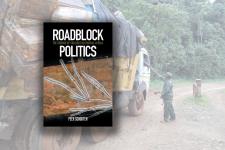 Diis book cover road block politics with picture of military stopping truck for check
