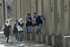 School-girls-running-next-to-the-security-barrier-in-east-jerusalem